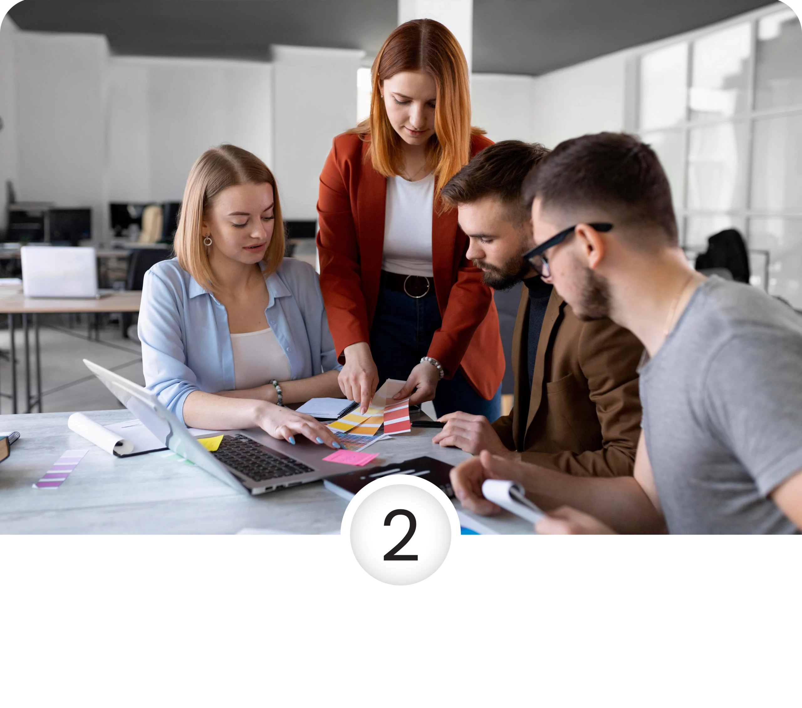 four people sitting infront of a laptop